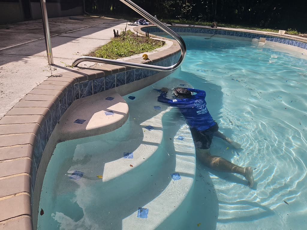 Malibu technician locating a pool leak underwater in Orlando